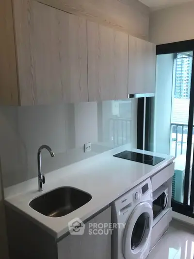 Modern kitchen with sleek cabinetry, built-in appliances, and large window for natural light.