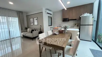 Modern open-plan living room and kitchen with sleek furniture and natural light.