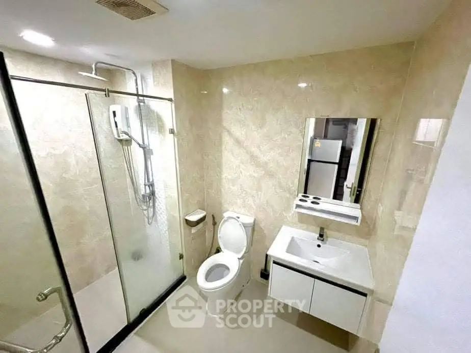 Modern bathroom with glass shower and sleek fixtures in a contemporary apartment.
