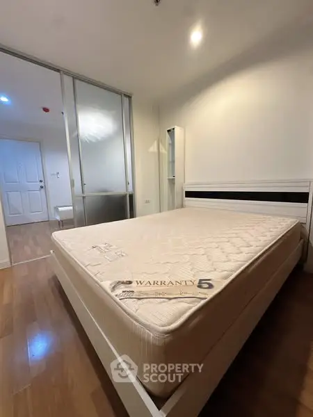 Spacious bedroom with modern design and warranty mattress in a stylish apartment.