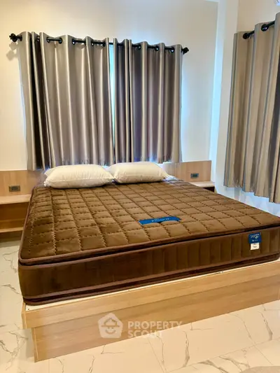 Spacious bedroom with modern decor and large windows for natural light.