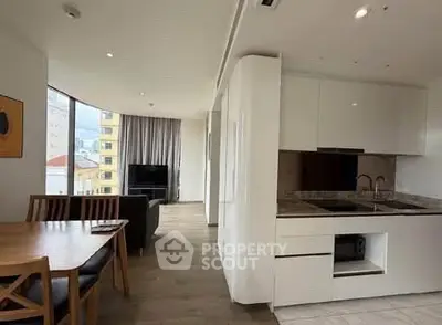 Spacious modern apartment with open kitchen and living area, featuring large windows and stylish furnishings.