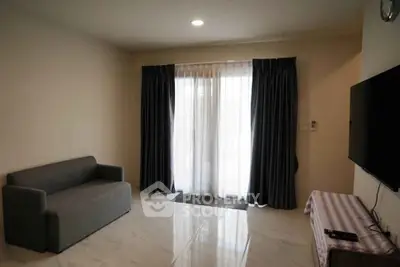 Modern living room with sleek sofa and wall-mounted TV, featuring elegant curtains and polished flooring.