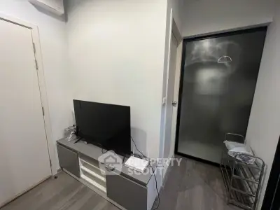 Modern compact living room with sleek TV stand and frosted glass door