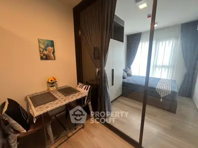 Cozy modern bedroom with glass partition and dining area, featuring elegant decor and natural light.