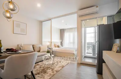 Modern open-plan living room with cozy bedroom and balcony view, perfect for urban living.