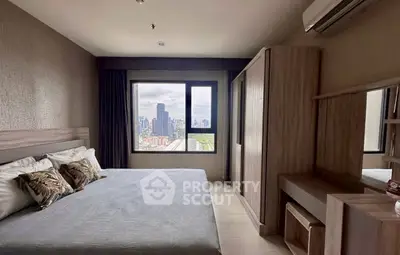 Spacious bedroom with city view, featuring modern furniture and large window for natural light.