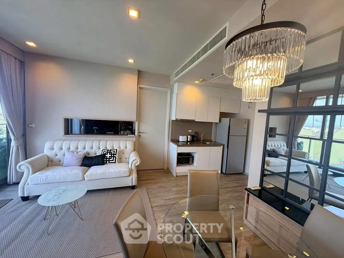 Luxurious modern living room with elegant chandelier and open kitchen layout