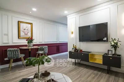 Stylish living room with modern decor, wall-mounted TV, and elegant dining area.