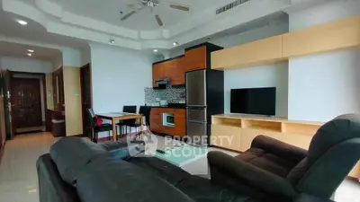 Spacious modern living room with sleek furniture and open kitchen layout.