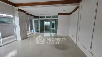 Spacious empty room with large windows and tiled flooring, ideal for customization.