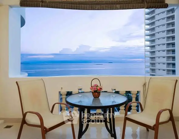 Stunning ocean view from a high-rise balcony with elegant seating area.