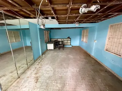 Spacious room with blue walls and mirrored accents, ideal for creative renovation.