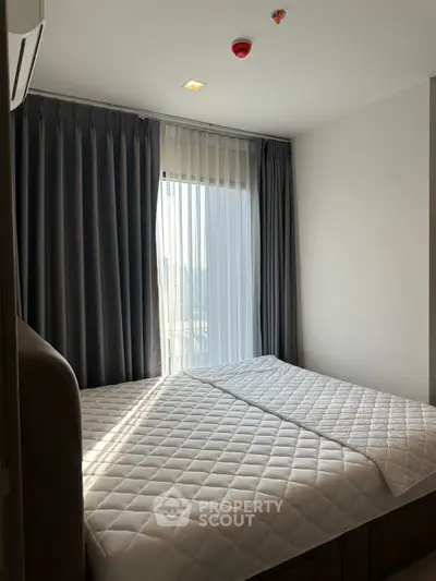Cozy bedroom with large window and elegant curtains, perfect for natural light lovers.