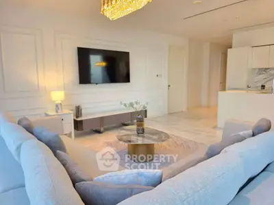Luxurious living room with modern decor and large TV, featuring a cozy sectional sofa and elegant lighting.