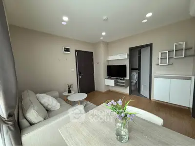 Modern living room with cozy sofa, TV, and dining area in a stylish apartment.