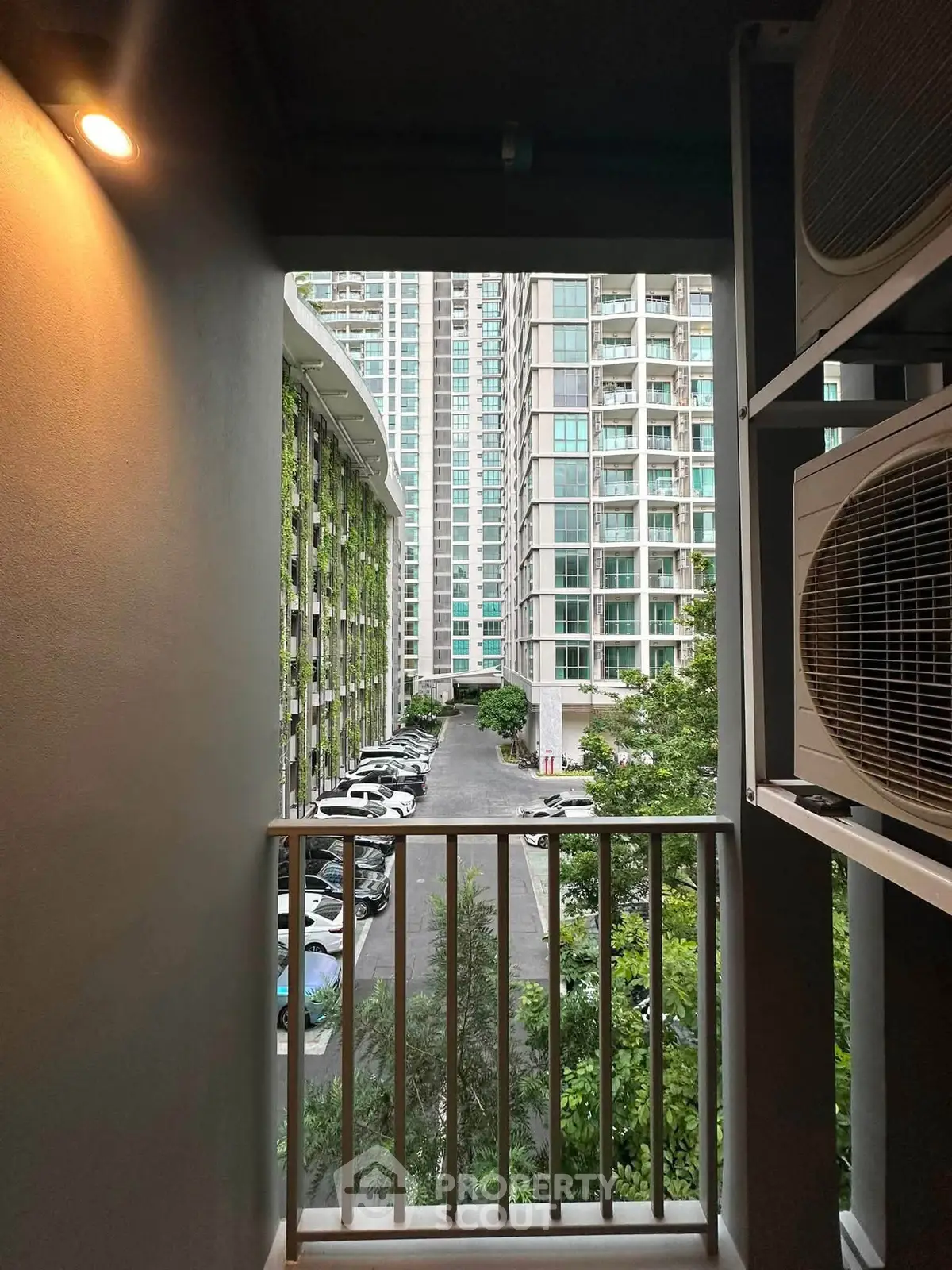 Modern urban apartment view with lush greenery and parking area