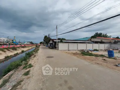 Spacious land plot with potential for development in a serene neighborhood, featuring nearby canal and road access.