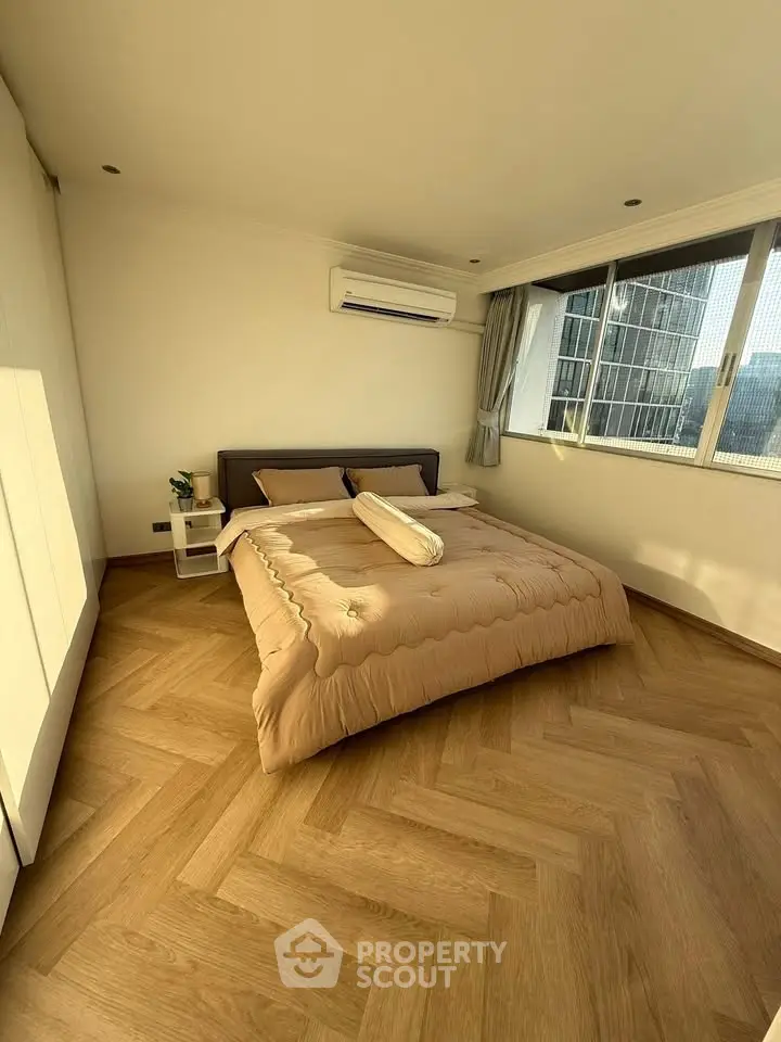 Spacious bedroom with modern design and large windows offering city views.