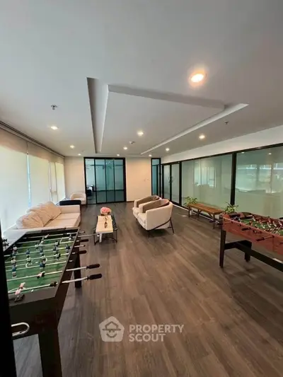 Spacious modern living room with foosball tables and cozy seating area