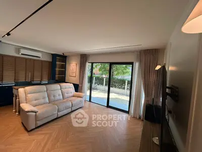 Spacious living room with modern decor and large sliding glass doors leading to a garden view.