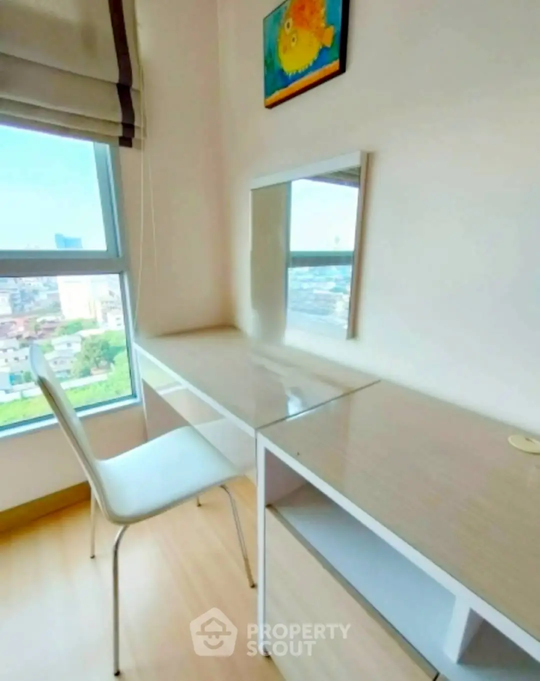 Bright study room with desk and chair, offering city views through large window.