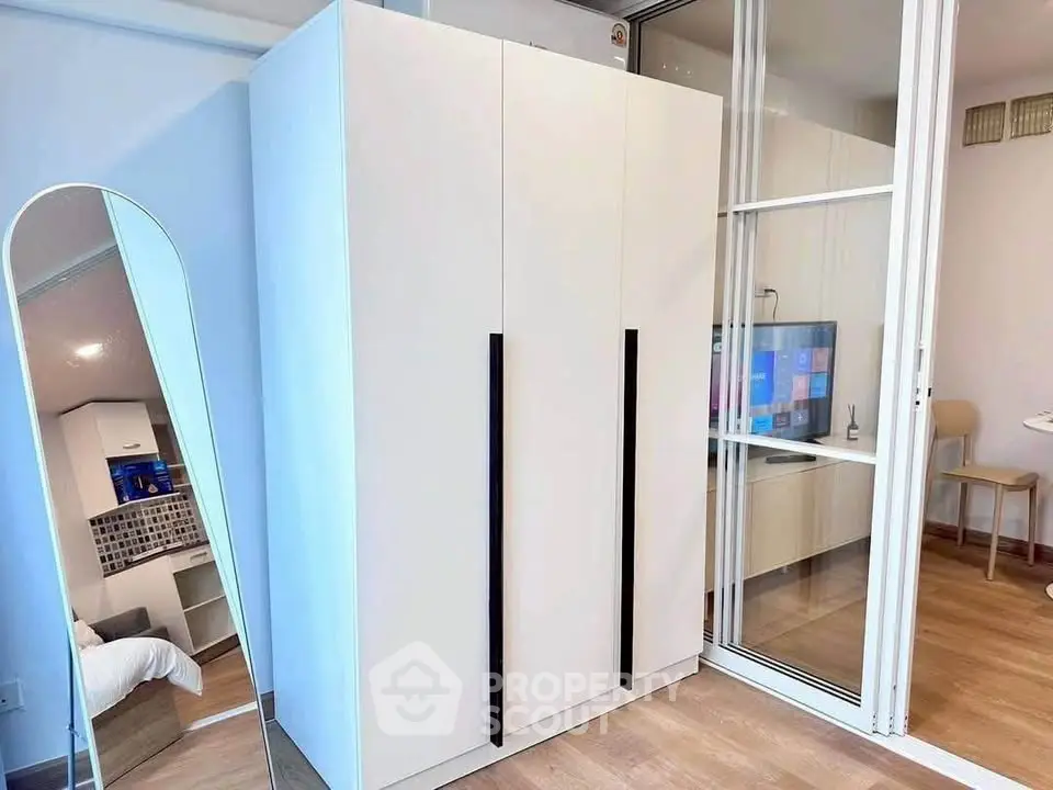 Modern interior with sleek wardrobe and mirrored accents in a stylish living space.