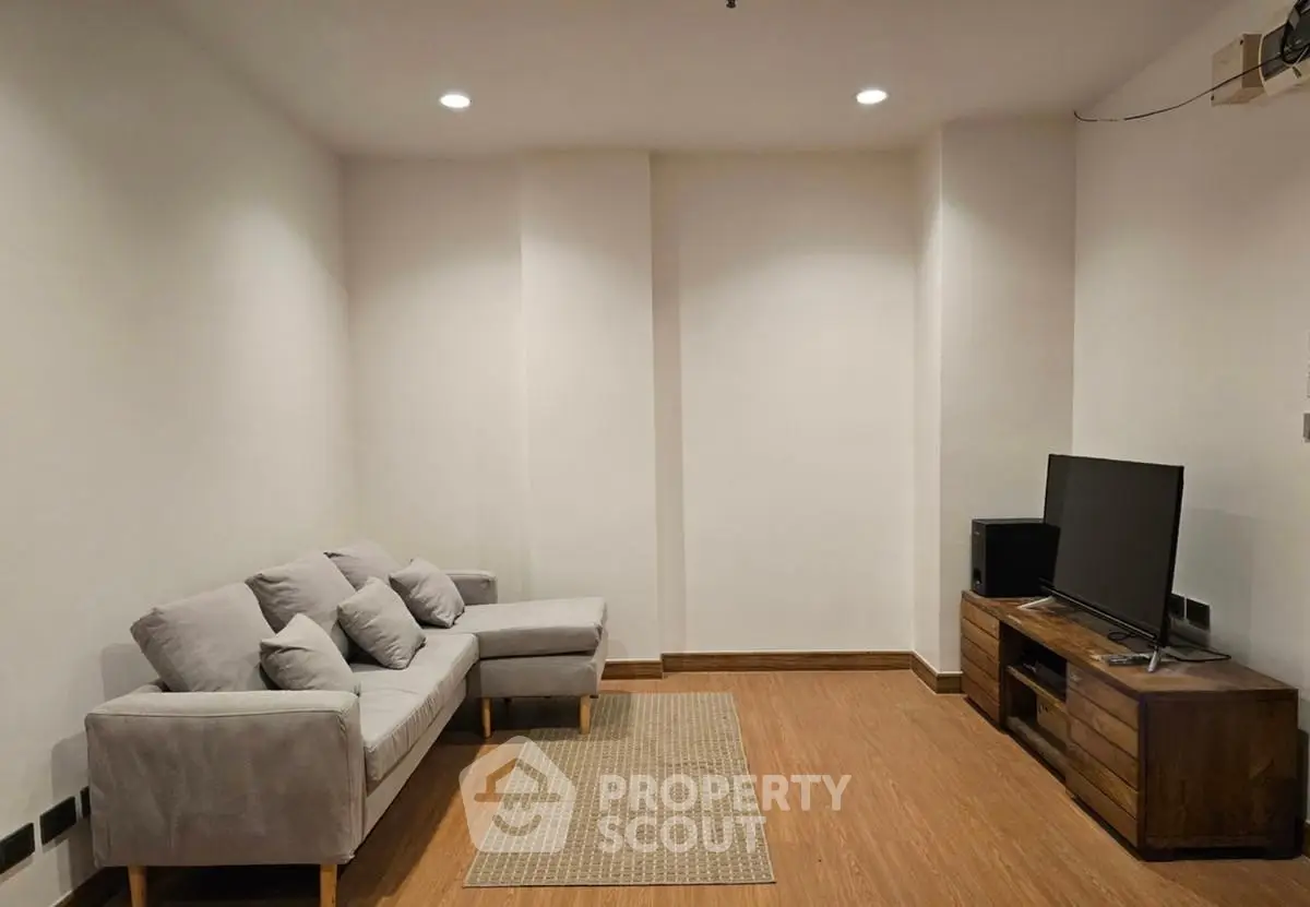 Cozy living room with modern sofa and entertainment unit, perfect for relaxation.