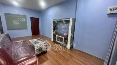 Modern living room with wrapped furniture and sleek wooden flooring