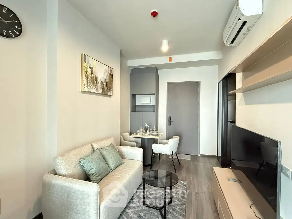 Modern living room with cozy sofa, dining area, and wall-mounted TV in stylish apartment.