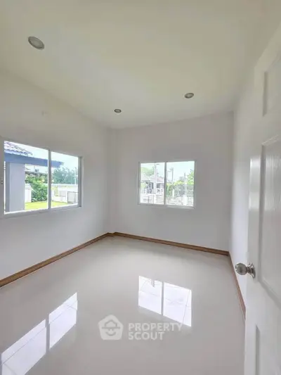 Bright empty room with large windows and glossy floor, perfect for customization.
