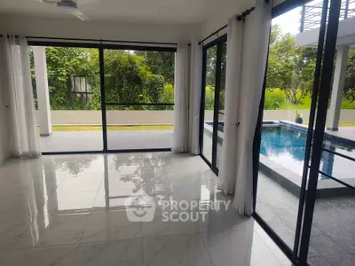 Spacious living room with pool view and large glass doors in modern home