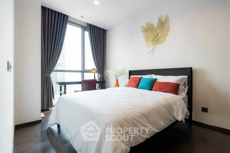Modern bedroom with stylish decor and large window view.