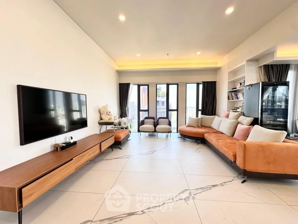Spacious modern living room with elegant decor and large windows offering natural light.