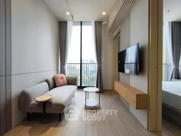 Modern living room with sleek furniture and large window offering city view