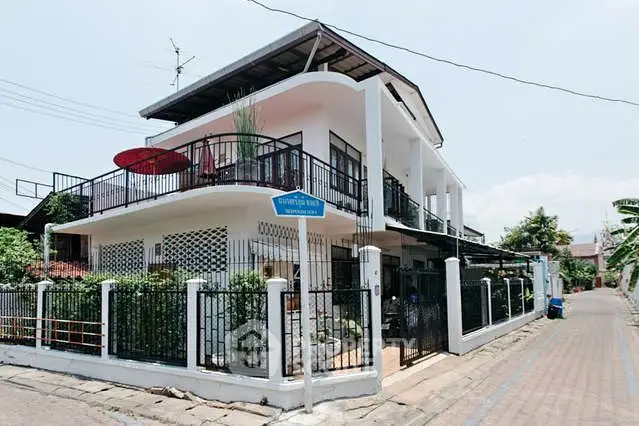 Charming two-story corner house with spacious balcony and lush garden in a serene neighborhood.