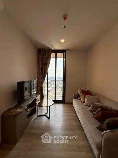 Cozy living room with modern decor and stunning city view from large window.