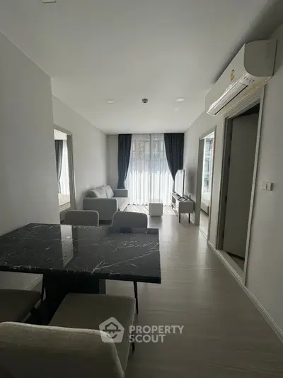 Modern living room with sleek furniture and large windows in a stylish apartment.