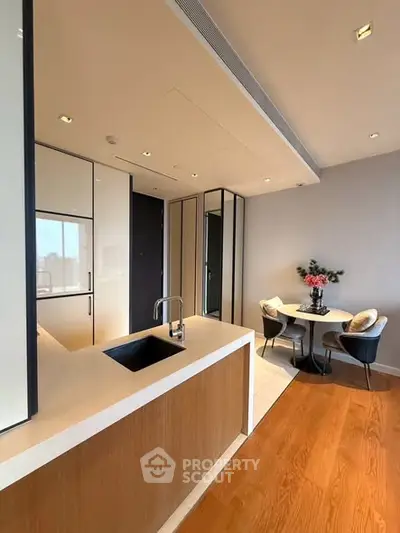 Modern kitchen with sleek design and cozy dining area, featuring a stylish open layout and elegant finishes.