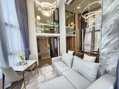 Luxurious modern living room with high ceilings and elegant chandeliers in a stylish apartment.