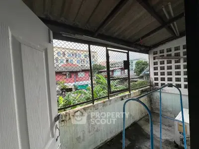 Rustic balcony with metal railing and urban view, perfect for renovation.