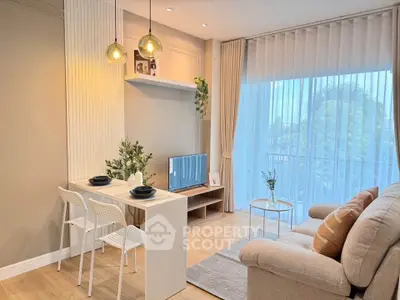 Modern living room with cozy seating and natural light from large windows, featuring stylish decor and dining area.