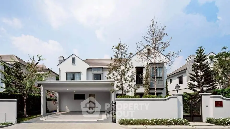 Elegant modern house with spacious driveway and lush greenery, perfect for luxurious living.