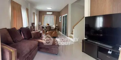 Spacious living room with modern decor and large TV, perfect for relaxation.