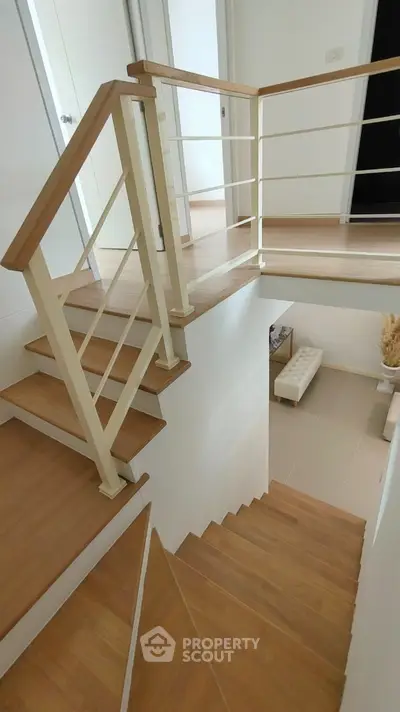 Modern wooden staircase with sleek railing in a contemporary home interior