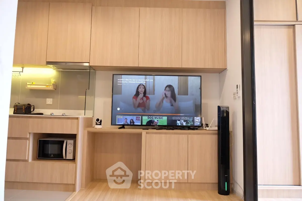 Modern living room with built-in wooden cabinetry and flat-screen TV, showcasing a stylish and functional interior design.