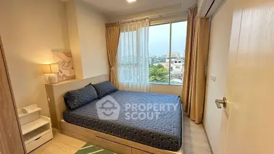 Cozy bedroom with large window offering city view, featuring modern decor and ample natural light.