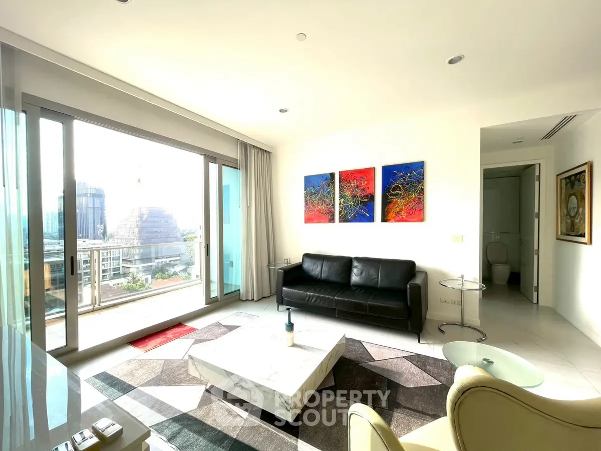 Modern living room with balcony view, stylish decor, and abundant natural light in a high-rise apartment.