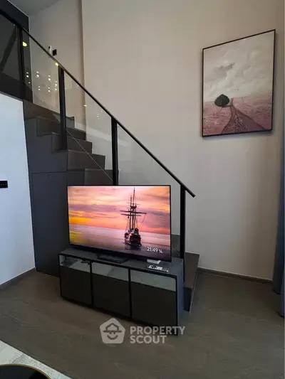 Modern living room with stylish staircase and mounted TV, perfect for contemporary urban living.