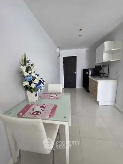 Modern kitchen with sleek white cabinets and dining area featuring floral decor